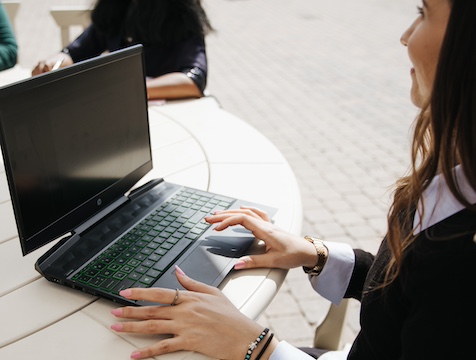 women outside a round table with a laptop