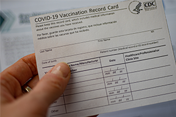 Person holding CDC COVID-19 Vaccination Record Card.