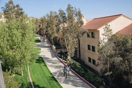 Students walking the exterior of the Drescher campus apartments