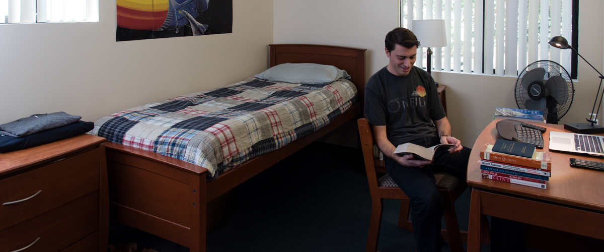 Graduate student reading in Drescher apartment single room