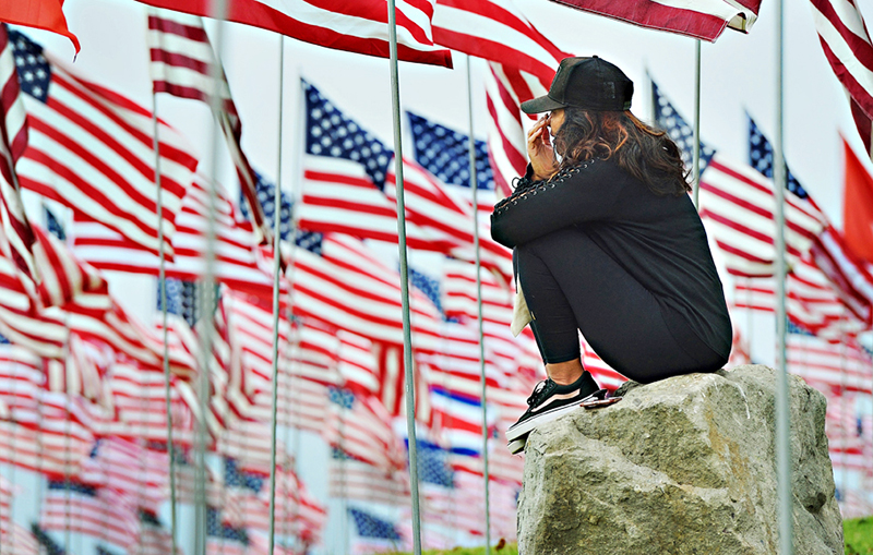 Angie Correa wipes away tears on the morning of September 11, 2018 at Pepperdine's Waves of Flags installation in Malibu.