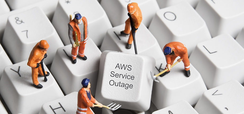 A miniature road crew work on an over-sized computer keyboard around a key labelled "Service Outage."