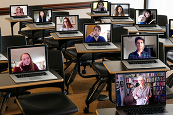 A classroom filled with laptops streaming student faces on student desks