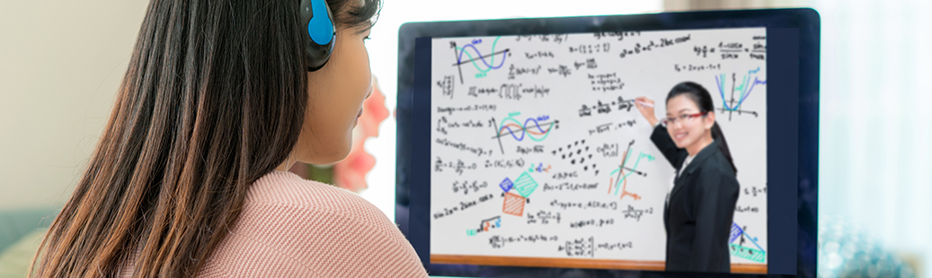 Zoom webinars allow Pepperdine departments and schools to host online events. In this example, a female student watches a webinar with the professor lecturing at a whiteboard.