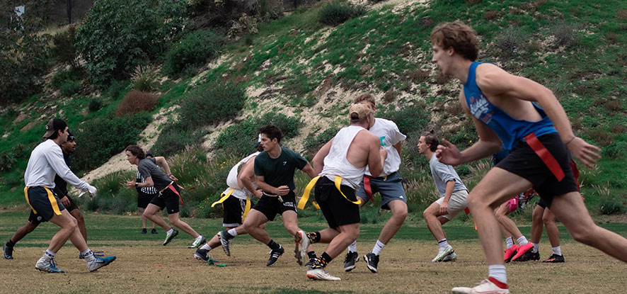 Students mid-run playing flag football