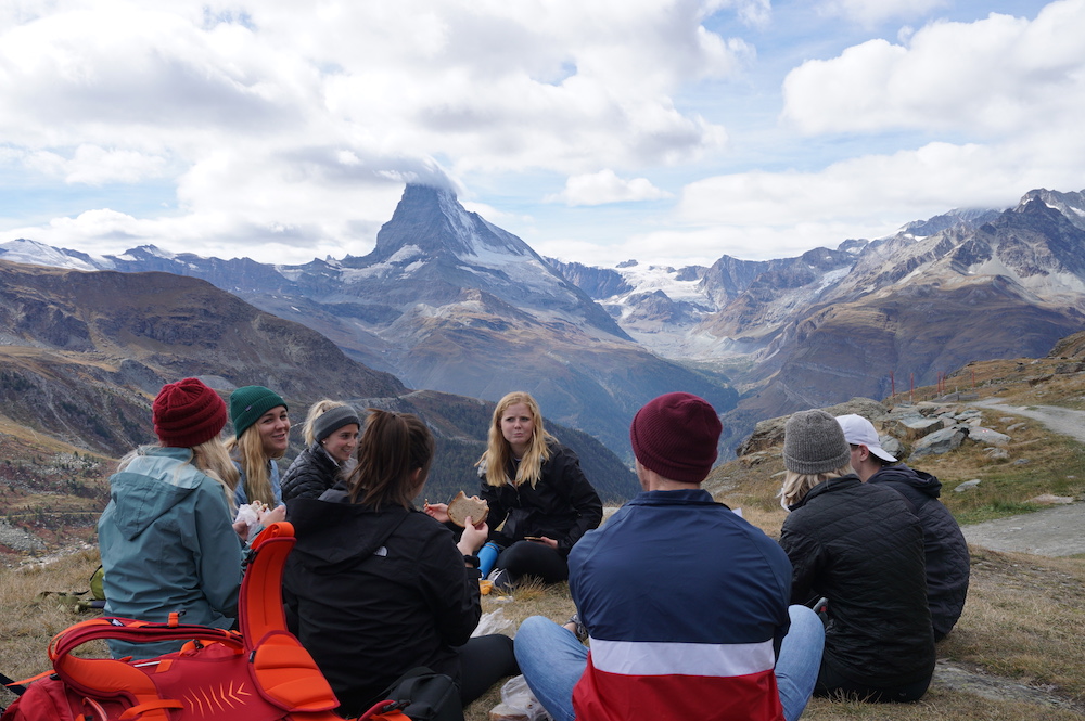 students eating lunch on top of a mountain