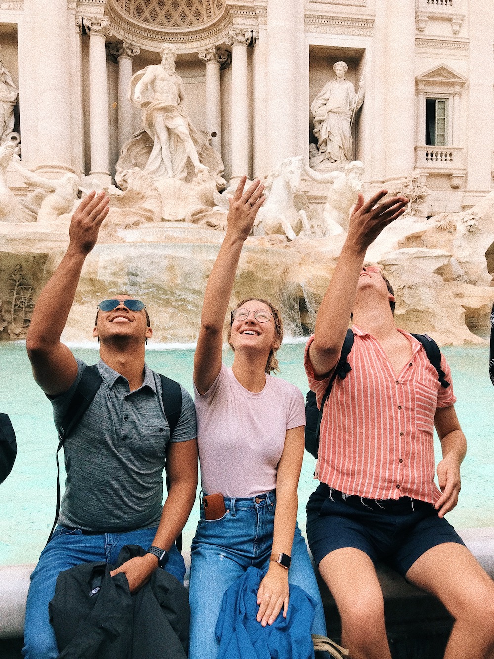 students throwing coins into the trevi fountain